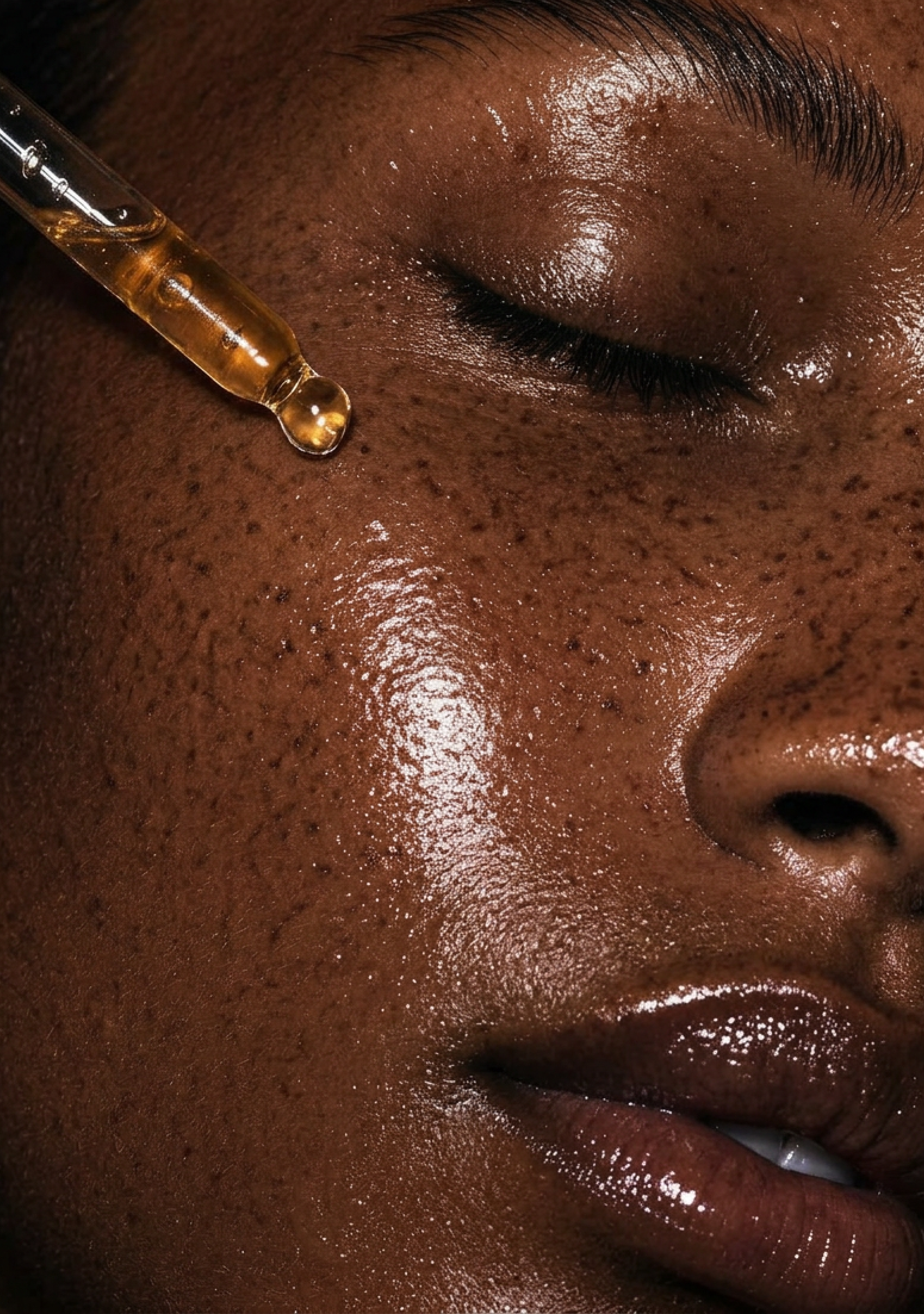 Close-up of a person's face with closed eyes and a glass dropper applying amber liquid to the skin.